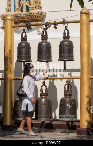 YOUNG THAI WOMAN RINGING THE BELLS OUTSIDE THE WAT PHRA THAT DOI SUTHEP TEMPLE CHIANG MAI THAILAND ASIA Stock Photo