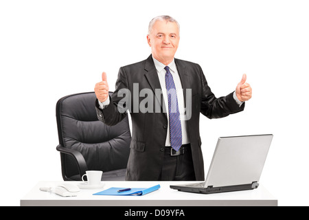 Mature businessman standing in his office and giving thumbs up Stock Photo