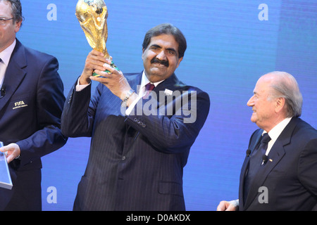 Sheikh Hamad bin Khalifa Al-Thani, Emir of Qatar, holds the World Cup trophy recieved from FIFA President Joseph Blatter (r) Stock Photo