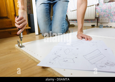 DIY. A woman assembling IKEA flat pack furniture. Stock Photo