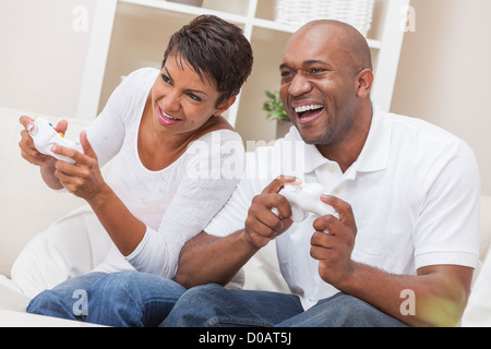 African American couple, man and woman, having fun playing video console games together Stock Photo