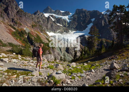 Hiker on the Lake Ann Trail with view of Mount Shuksan and the Upper and Lower Curtis Glacier; in the Mount Baker Wilderness. Stock Photo