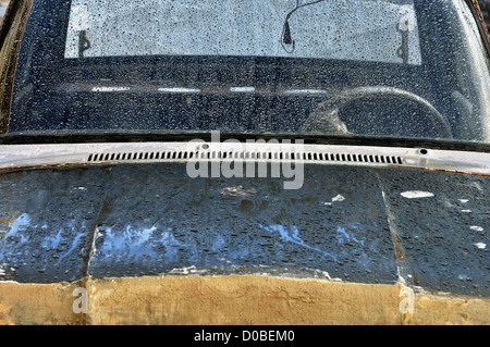 Vintage car scraped hood and rain covered windscreen. Stock Photo