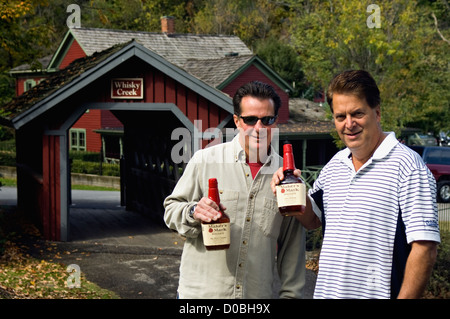 Two Men Holding Up Bottles of Maker's Mark Bourbon while Visiting Maker's Mark Distillery in Loretto, Kentucky Stock Photo