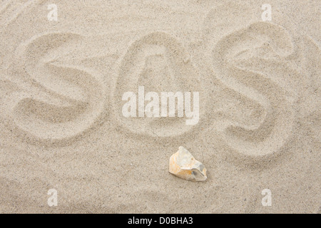 SOS letters written in sand Stock Photo