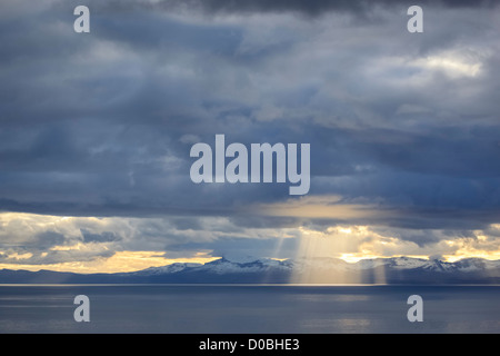 A ray of light breaks through the cloud over the Isle of Skye as sunset approaches in the Scottish Highlands. Stock Photo