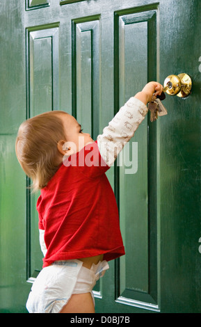 Eighteen Month Old Boy Trying to Unlock Door with Keys Stock Photo