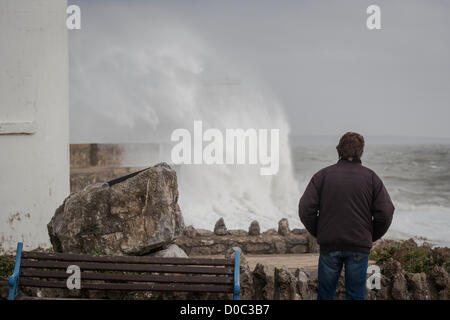 People watch large waves break on the sea wall at Porthcawl, South Wales, UK on Thursday 22nd Novermber, 2012. The UK is braced for bad weather as a strong winds and heavy rain move across the country with weather warnings in place. Stock Photo