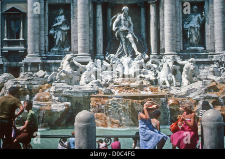 ITALY ROME PEOPLE RELAX IN THE SUNSHINE BY THE FAMOUS TREVI FOUNTAIN Stock Photo