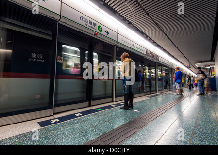 Passengers waiting for the train at metro subway station, Hong Kong, China Stock Photo