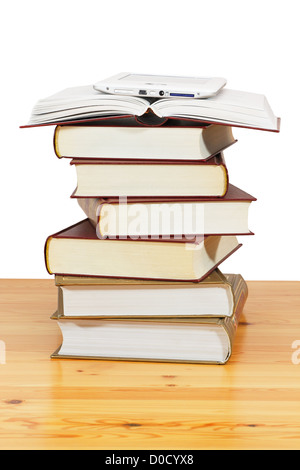 A pile of books and e-book above on wood table against a white background Stock Photo