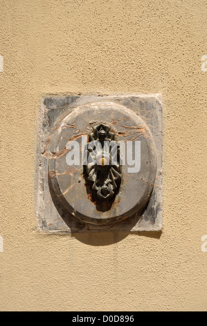 Old door bell set in a marble back plate next to a doorway in Lucca Tuscany Italy Stock Photo