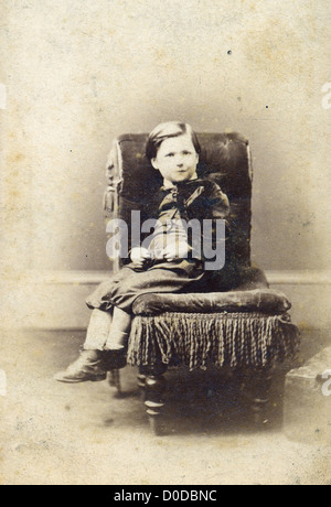 Portrait of young boy on chair. Sourced from cabinet card vintage photograph by A.D. Lewis, Newcastle on Tyne, UK, circa 1870. Stock Photo