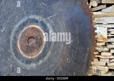 Vintage cutting wheel and pile of marble scrap. Rusty industrial equipment. Stock Photo