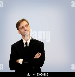 Young business in black suit looking upwards and thinking Stock Photo