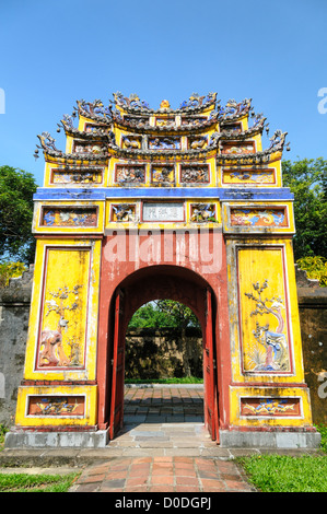 HUE, Vietnam - A brighly colored courtyard gate at the Imperial City in Hue, Vietnam. A self-enclosed and fortified palace, the complex includes the Purple Forbidden City, which was the inner sanctum of the imperial household, as well as temples, courtyards, gardens, and other buildings. Much of the Imperial City was damaged or destroyed during the Vietnam War. It is now designated as a UNESCO World Heritage site. Stock Photo