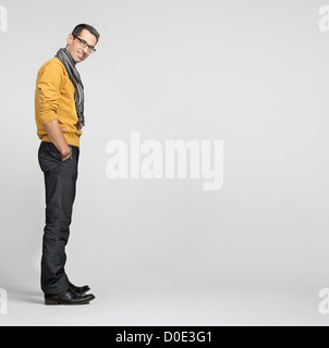 Handsome dark-haired man casually leaning against the wall Stock Photo
