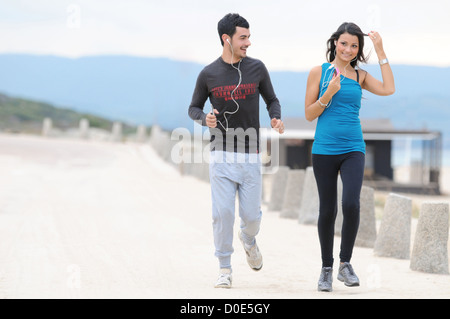 Young couple running and jogging on beach Stock Photo