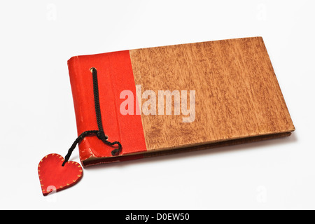 Detailansicht eines alten Tagebuches an dem ein kleines rotes Herz hängt | Detail photo of an old diary, with a small red heart