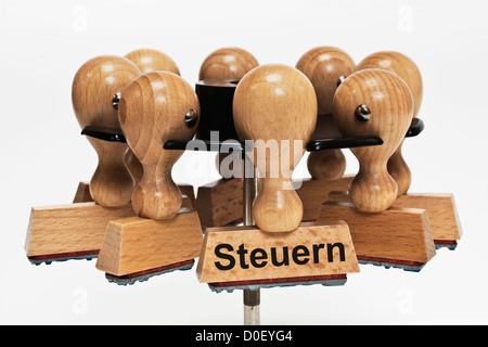 Many stamps hanging in a stamp rack, one with the German inscription Steuern (Taxes), background white. Stock Photo
