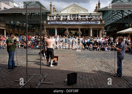 Some street artists are making a show before Covent Garden Market in Covent Garden Piazza, London. Stock Photo
