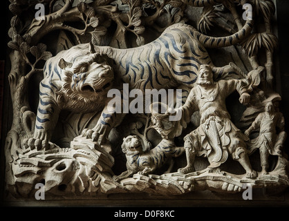 A Chinese stone carving in a temple in Taiwan depicting a man fighting a large tiger Stock Photo