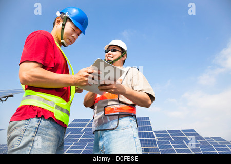 two workers discussing with tablet pc before solar power station Stock Photo