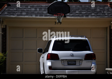 A basket-ball net attached to a garage roof above a parked car Ontario, Canada Stock Photo