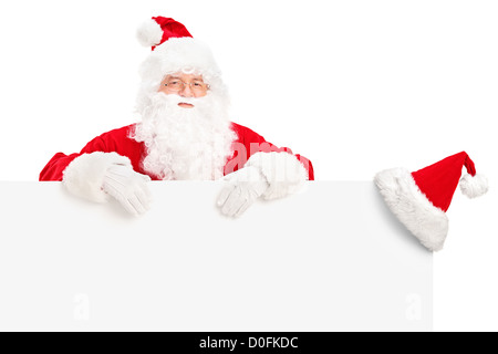 Santa Claus posing behind a blank billboard isolated on white background Stock Photo