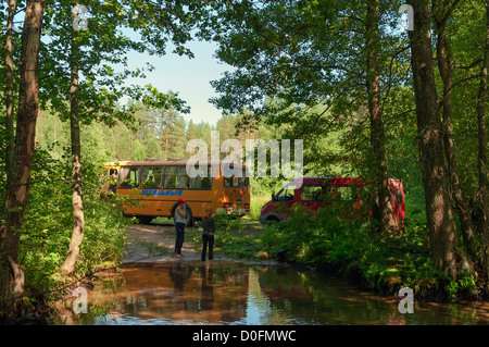 The yellow bus tows the red minibus. Stock Photo