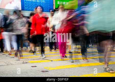 Pedestrians in blurred motion while crossing Nathan Road, Kowloon, Hong Kong, China Stock Photo