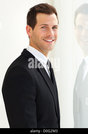 Young and attractive male smiles at the camera while wearing a suit Stock Photo