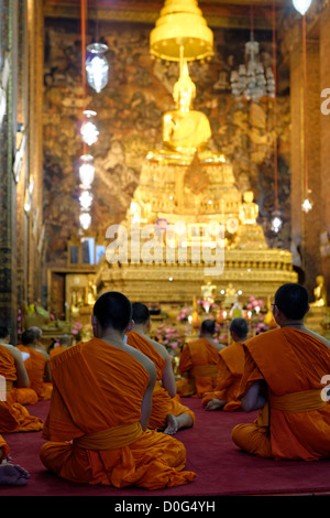 Monks praying in Phra Ubosot Hall, Wat Pho Temple, Bangkok, Thailand Stock Photo