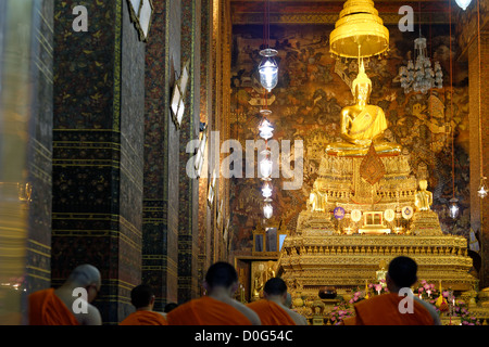 Monks praying in Phra Ubosot Hall, Wat Pho Temple, Bangkok, Thailand Stock Photo