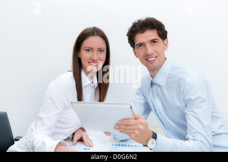 Businessman and businesswoman at the workplace planning with digital tablet. Stock Photo