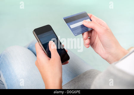 Woman verifies account balance on smartphone with mobile banking application. Stock Photo