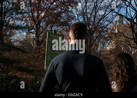 Visitors read the map posted in the Shakespeare garden in New York's Central Park. Stock Photo