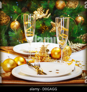 Image of Christmas dinner in restaurant, Christmastime table setting over decorated fir tree background, white plates Stock Photo