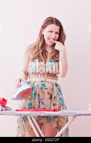 woman ironing and burning a finger Stock Photo