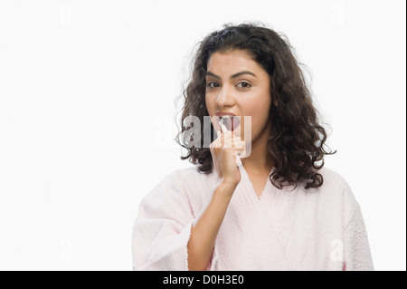 Portrait of a young woman brushing her teeth Stock Photo