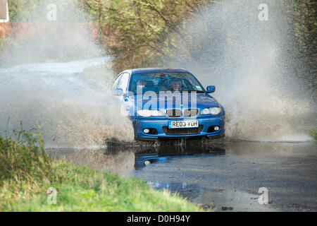 Billericay, Essex, UK. Recent heavy rain and waterlogged ground has lead to a lot of surface water in places throughout Essex. This has caught some drivers out as they hit these puddles at speed which can lead to flooded engines and coming to a halt in the water. A BMW splashes through a puddle. Stock Photo