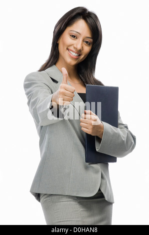 Portrait of a businesswoman holding files and showing thumbs up Stock Photo