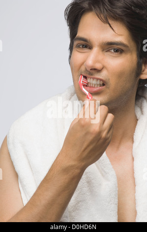 Portrait of a young man brushing his teeth Stock Photo