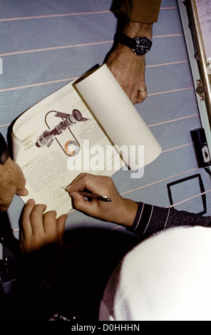 The hands of Cosmonaut Valerly N. Kubasov are seen as the Apollo Soyuz Test Project (ASTP) engineer adds his name to the signatu Stock Photo