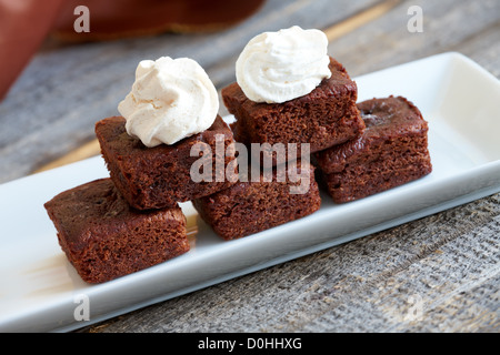 Little soft chocolate brownies with white meringue on top served in elegant style. Stock Photo