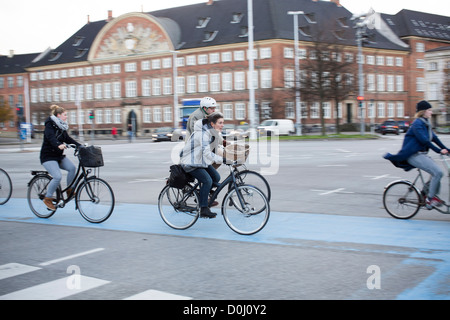 Commuters ride their bicycles along a cycle lane in Copenhagen, Denmark. The Danish city boasts a lot of bike riders. Stock Photo