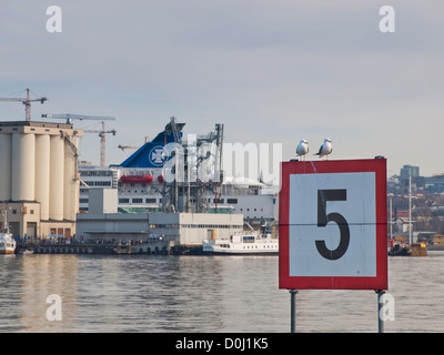 Speed limit sign at sea five 5 knots, in the harbour of Oslo Norway, grains silo and ferry to Denmark. Stock Photo