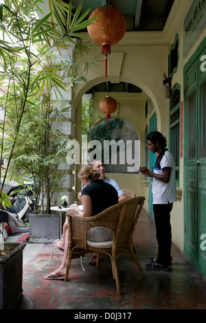 Tourists order coffee at one of Georgetown's many cafés in Penang, Malaysia Stock Photo