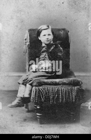 Portrait of boy on chair. Antique cabinet card vintage photograph created by A.D. Lewis, Newcastle on Tyne, UK, circa 1870. Stock Photo