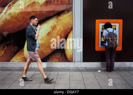 A man walking past a cash machine at Broadmead in Bristol. Stock Photo